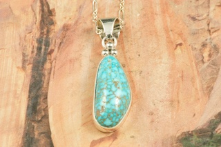Genuine High Grade Kingman Web Turquoise set in Sterling Silver Pendant. Created by Navajo Artist Lucy Valencia. Signed L. J. by the artist. The Mineral Park Mine, in the Cerbat Mountains 14 miles northwest of Kingman, was first mined by Indians centuries before white man came to the area. It is one of the three sites of prehistoric mining localities in the state of Arizona. Mineral Park was the most extensively worked area by the Indians of the three. S.A. �Chuck� Colbaugh found a cache of stone hammers uncovered in ancient trenches and tunnels, when he had the turquoise mining concession in May of 1962. Ithaca Peak and Turquoise Mine (formally called Aztec Mountain or Aztec Peak) are the most famous of the peaks in the area containing turquoise. Free 18